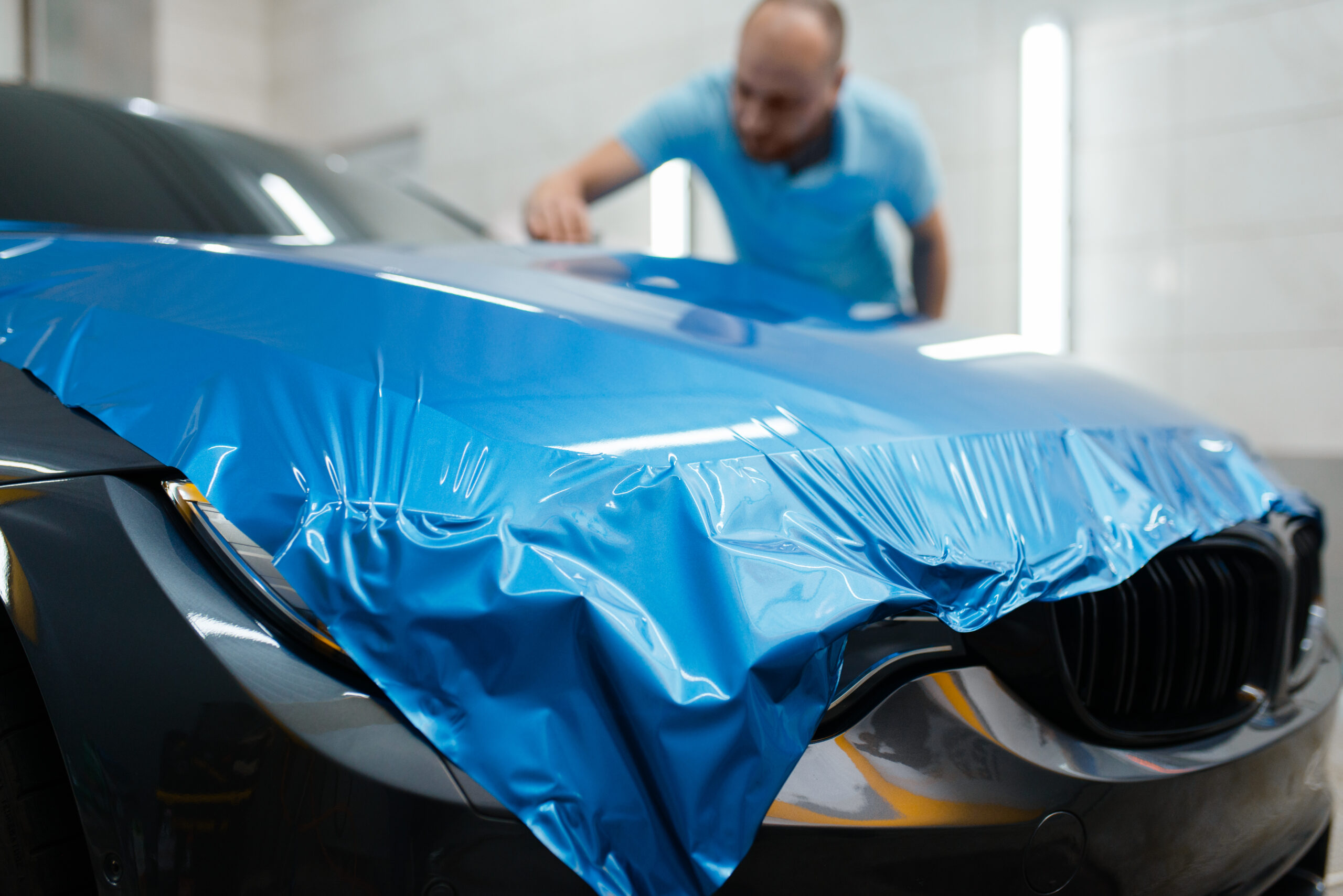 Oohwoow! Car wrapping, man installs protective vinyl foil or film on hood. 